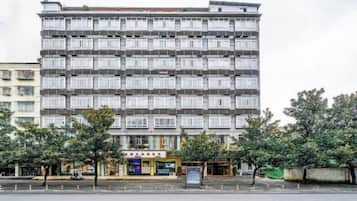 A multi-story hotel with a uniform facade, multiple balconies, and a ground-level commercial area.