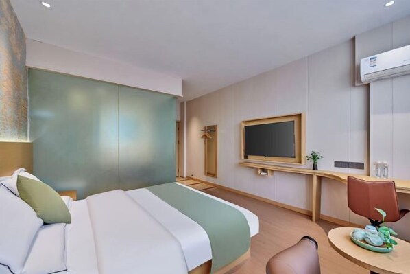 A hotel room with a bed, a desk, a chair, a television, and an air conditioning unit. - Yiju Qingyue Hotel (Xishui)