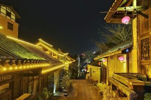 A traditional street at night with illuminated buildings and lanterns.