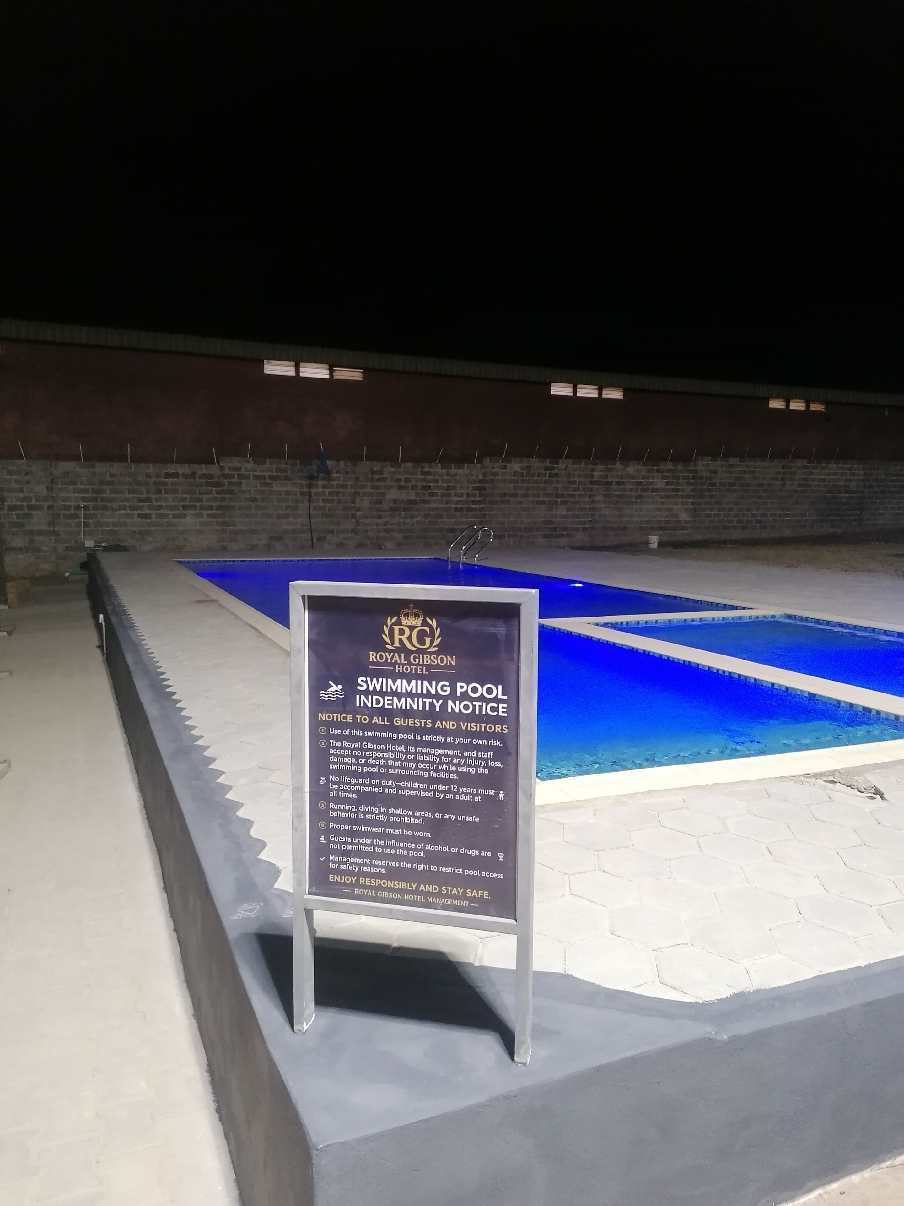 Ein Swimmingpool mit einem Sicherheitshinweisschild davor.