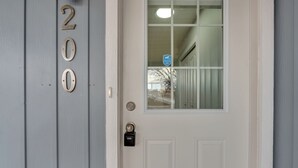 Una puerta blanca con ventana y timbre.