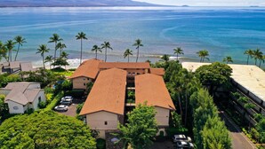 A coastal hotel with multiple buildings, a parking area, and a view of the ocean. - Suite Maui Paradise Condo (Wailuku)
