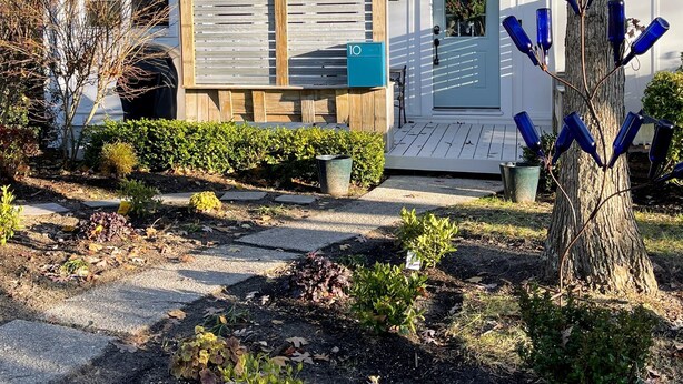 A two-story house with a front porch, a mailbox, and a tree with blue bottle decorations. - 10 Braddock Somers Point (Somers Point)