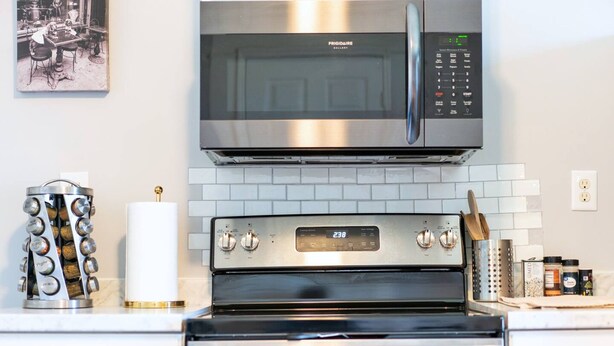 Une cuisine équipée d’un four à micro-ondes, d’un four et d’une machine à café, tous en acier inoxydable.
