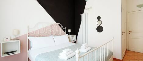 A neatly arranged bedroom with a bed, bedside table, and a wall-mounted radiator.