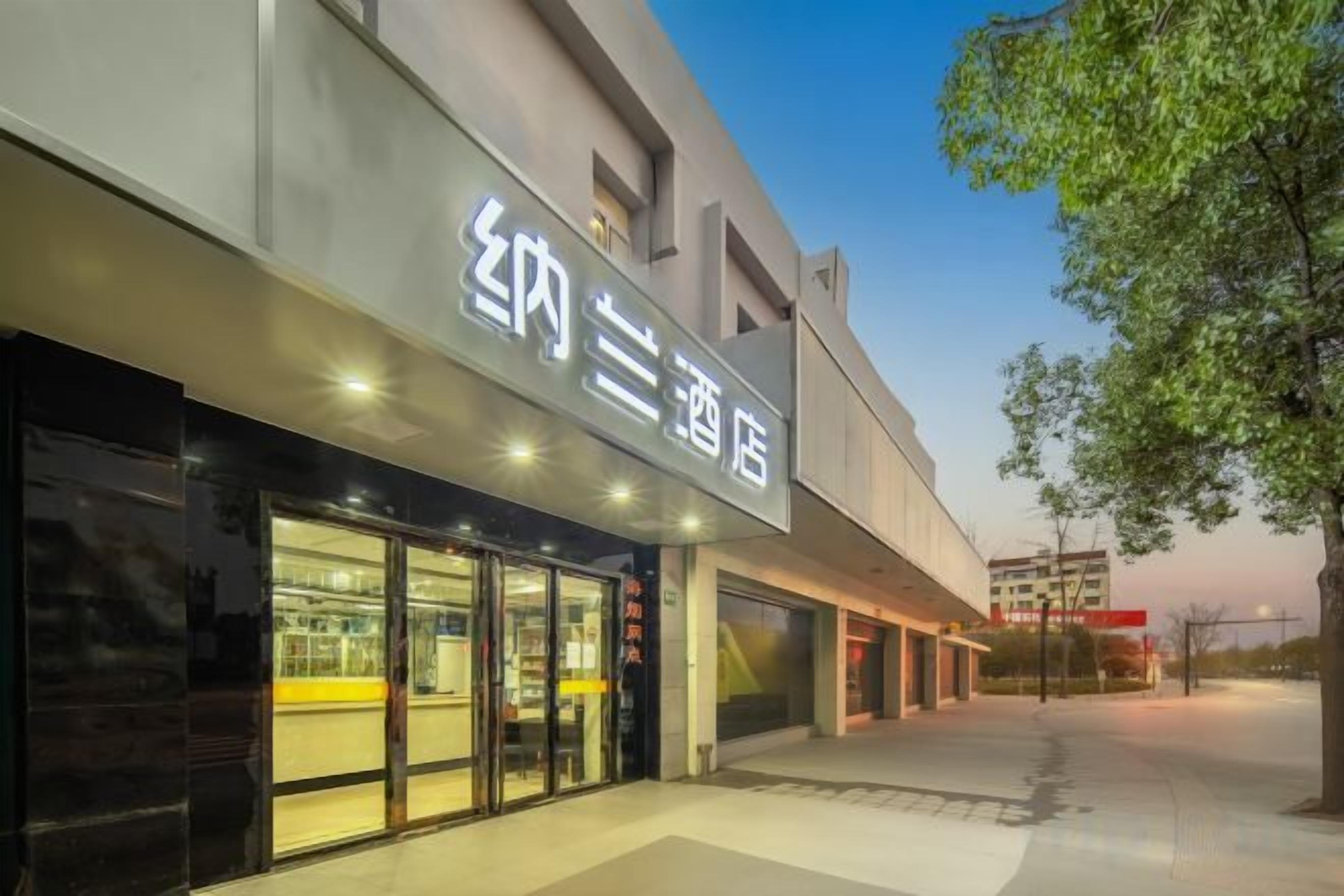 A hotel with a modern facade, large glass windows, and a visible entrance.