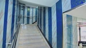 A marble staircase with glass railings leading to a higher floor. - Nalan Hotel (Shanghai)
