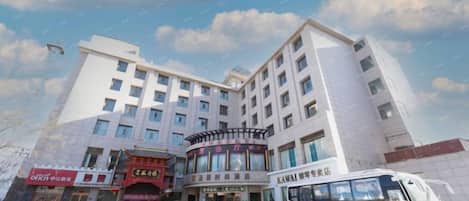 A multi-story hotel with a parking lot in front.