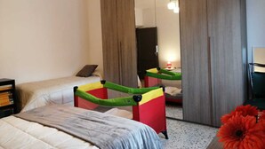Un dormitorio con una cama, un escritorio pequeño, un espejo y un armario.