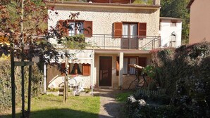 Una casa de dos pisos con un sendero de piedra que lleva a la entrada.