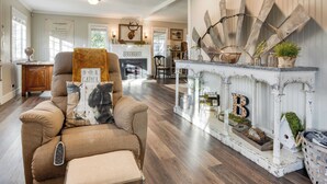 A cozy living room with a fireplace, a comfortable sofa, and a rustic mantelpiece with decorative items. - Luxury Wine Country Haven Vineyard Views Near Top Wineries Adelaida Farmhouse (Paso Robles)