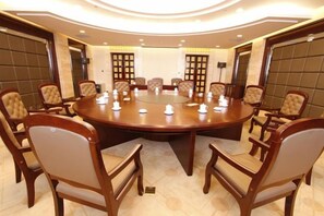 Une salle de conférence équipée d’une table ronde, de chaises et d’un tableau blanc.