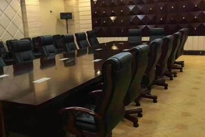 Una sala conferenze con un lungo tavolo e numerose sedie.