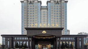 Un edificio grande con una entrada destacada y señalización que indica que es un hotel internacional.