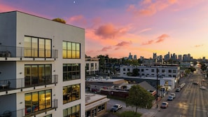 A multi-story building with balconies, large windows, and a city skyline in the background. - Dual Bachelor Pads w/ Rooftop Lounge & Games Sleeps 26 5 Min to Broadway (Nashville)