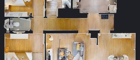 A hotel layout with multiple rooms, a central area with a seating arrangement, and a small outdoor space.