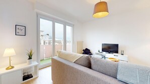 A modern living room with a sofa, a television, and a pendant light. - La belle étape + 1 parking (Colmar)