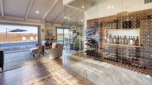Un interior moderno con un botellero, una zona de estar y vistas al exterior.