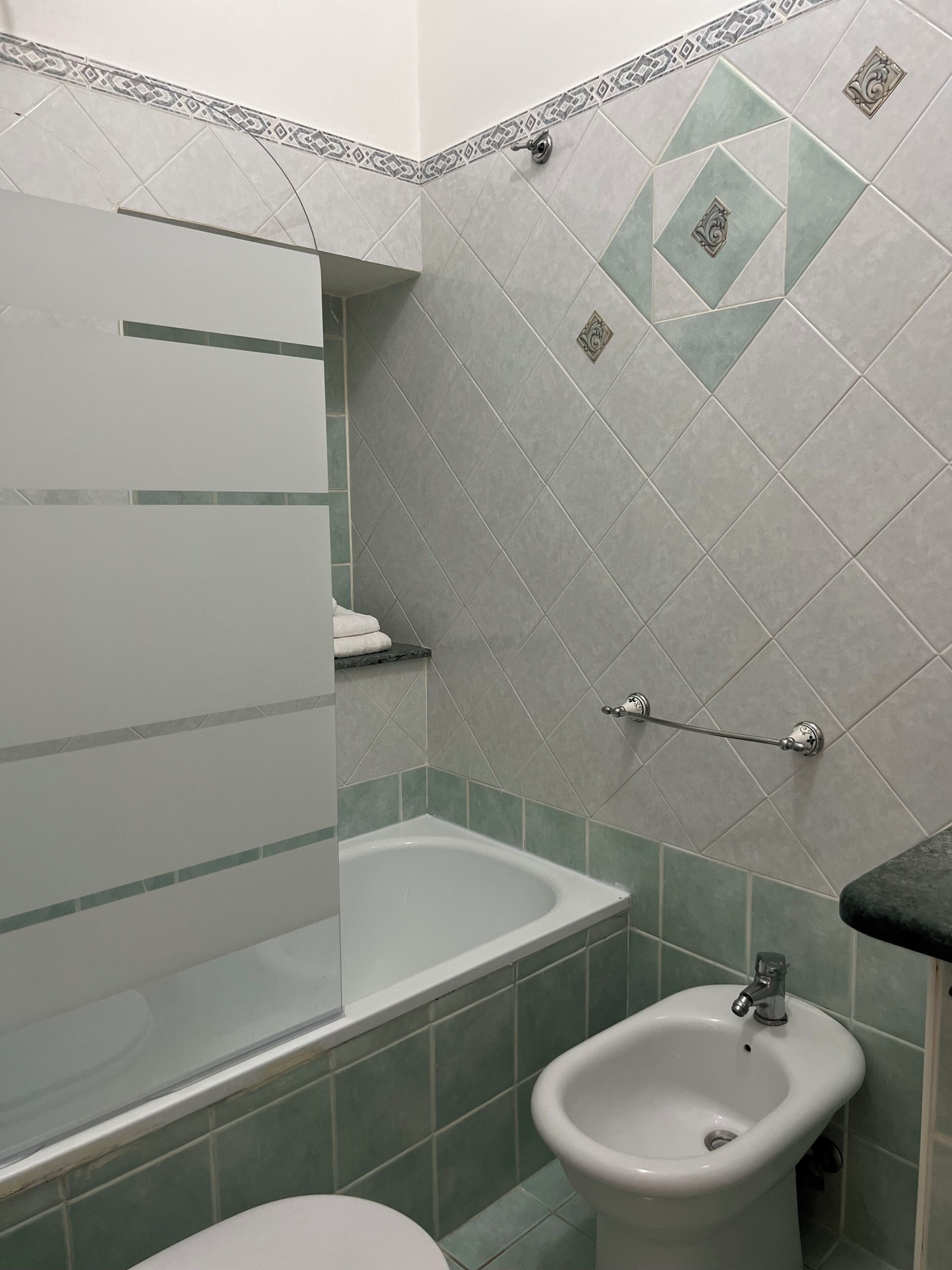 Een badkamer met een bad, een hygiëneschuimer en een toilet.