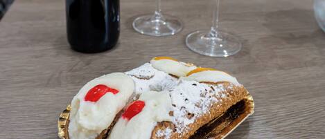 Une bouteille de vin rouge de Merlot, deux verres à vin vides et un dessert sur une table.