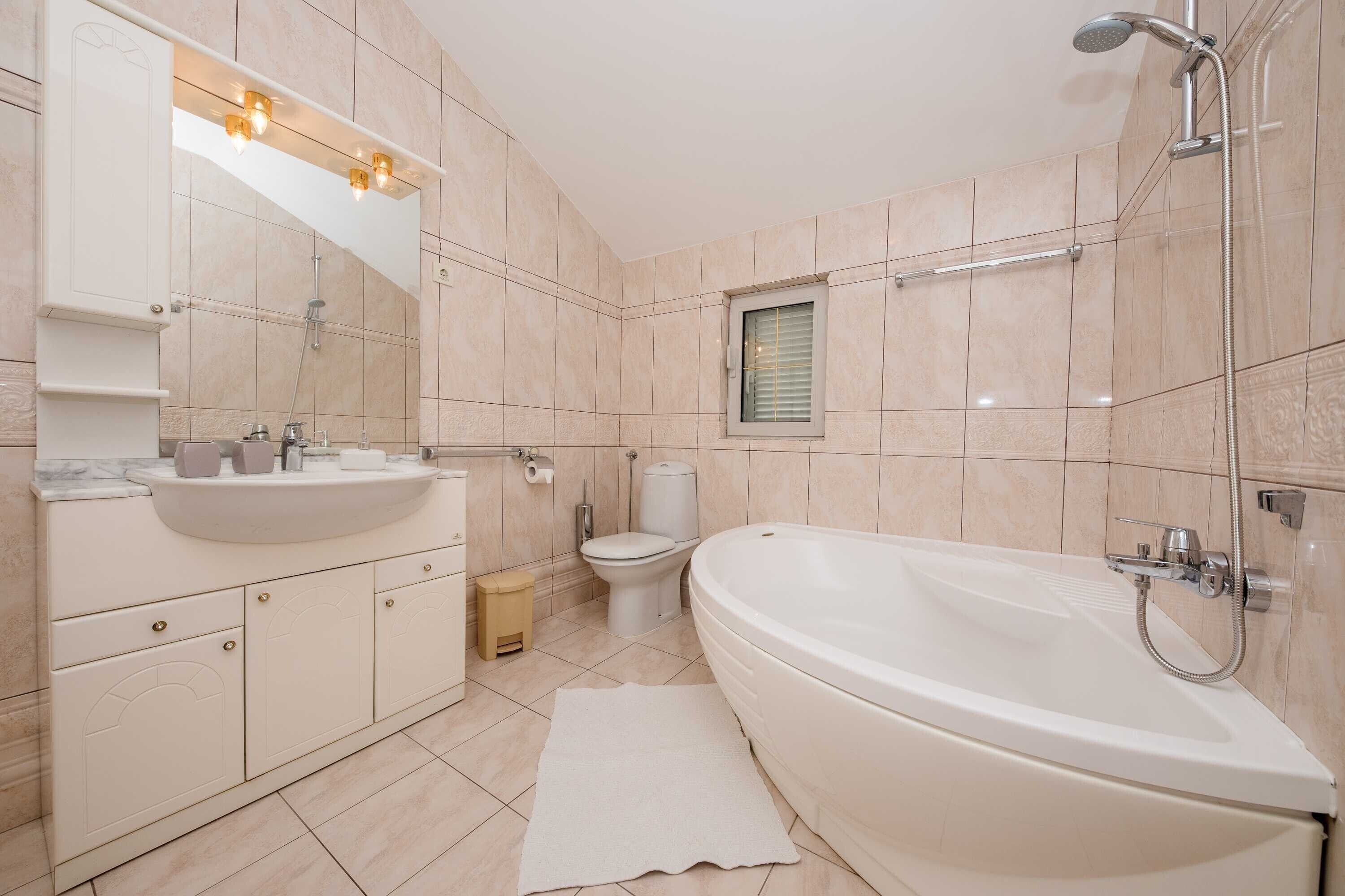 A modern bathroom with a freestanding bathtub, a vanity with a sink, and a toilet.