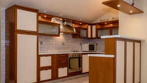 A kitchen with wooden cabinets, a microwave, and a stove.