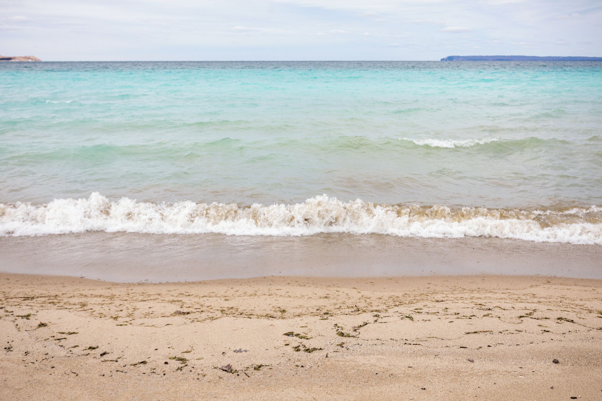Une plage à l’eau turquoise et limpide, où les vagues sont douces.