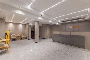 A reception area with a reception desk, seating area, and a staircase. - Shuyi Express Hotel (Shanghai)