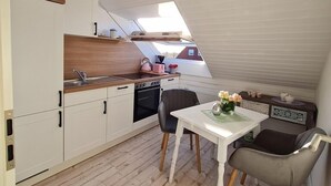 A compact kitchen with white cabinets, a wooden countertop, and a skylight. - Vacation apartment "Still Hörn 1" in Greetsiel (approx. 30 sqm / 2 persons) (Krummhörn)