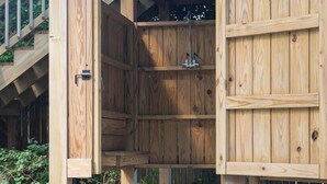 Eine Holzhütte mit einem Steinweg, der davorhin führt, mit einer Tür und einem kleinen Fenster.