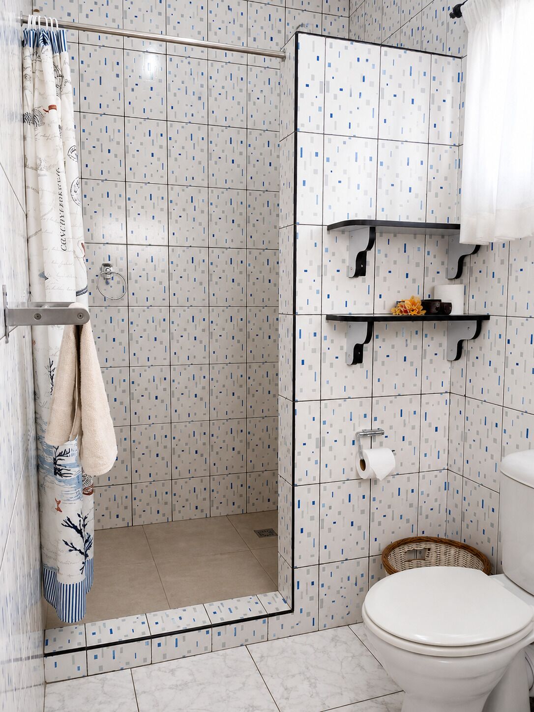 A bathroom with a shower, toilet, and shelves with toiletries.