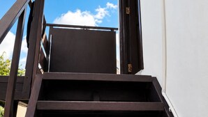 A set of outdoor stairs leading to a building entrance with a clear sky in the background. - Roche Kerlan Apartments (Praslin Island)