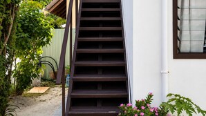 A staircase leading to a building's entrance, surrounded by greenery and a clear sky. - Roche Kerlan Apartments (Praslin Island)