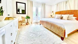 Une chambre à coucher avec un lit, une commode, un miroir et une fenêtre.
