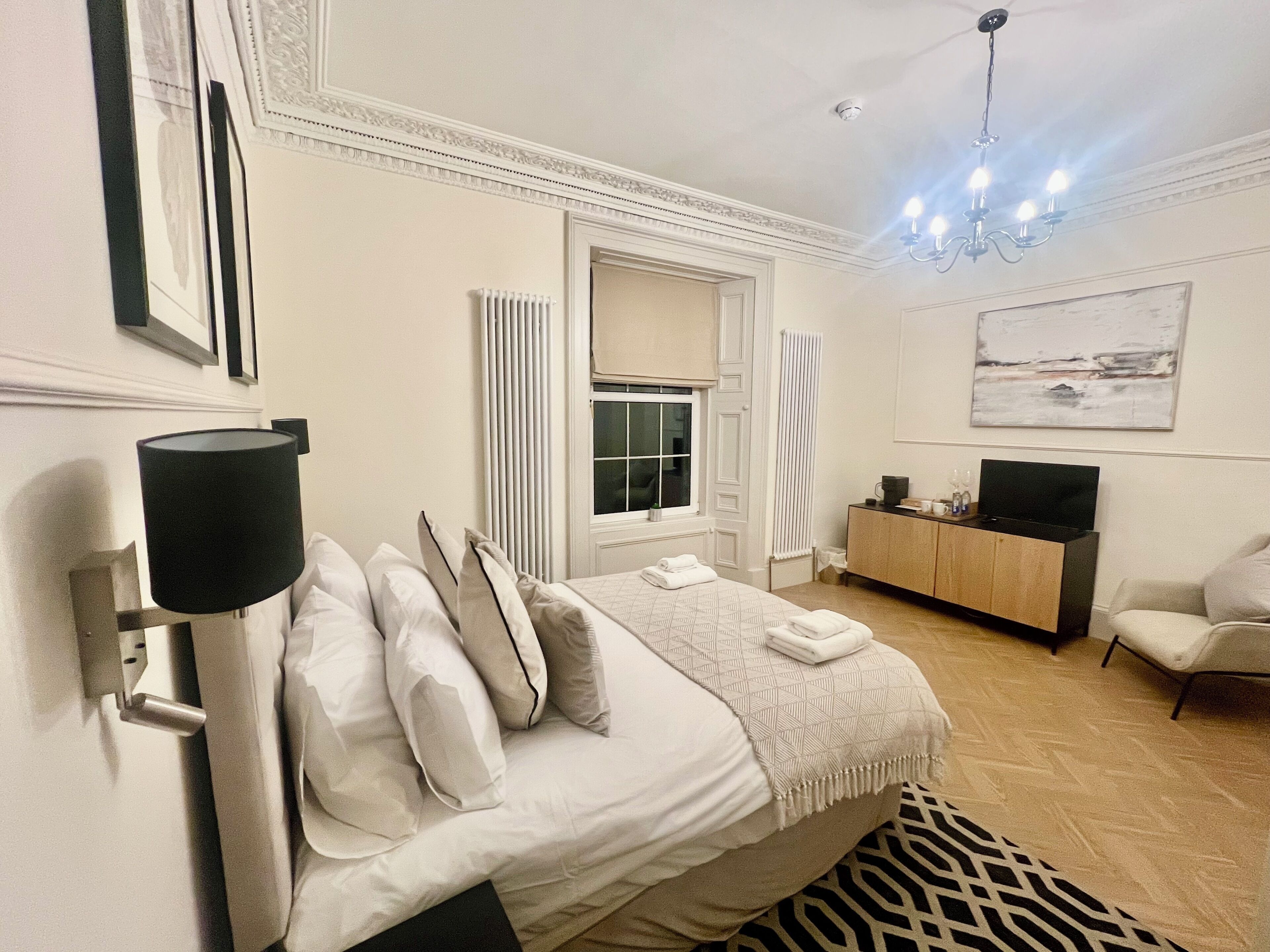 A hotel room with a bed, a television, a desk, and a chair.