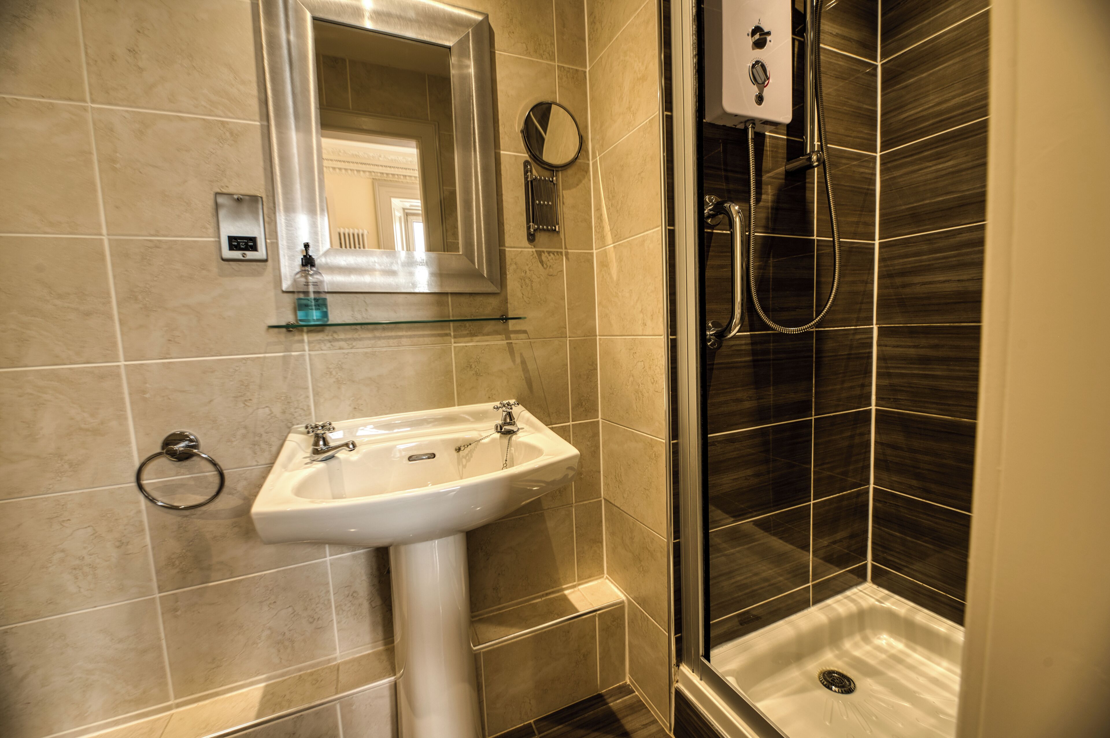 Un baño con lavamanos, espejo y ducha.