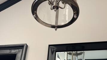 Un interior moderno con una gran lámpara de cristal y una puerta con marco negro.