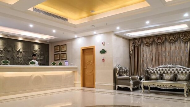 A lobby with a reception desk, a sofa, and a patterned carpet. - Vienna Hotel ( Liaocheng Tita Jinding Shopping Center Branch) (Liaocheng)