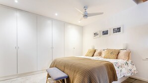 A bedroom with a bed, a bench, a ceiling fan, and a wardrobe. - Loft Market Mossen Sorell (Valencia)