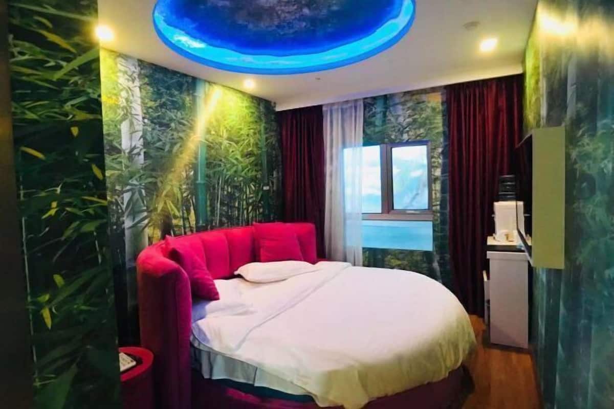 A bedroom with a bed, a window, and a ceiling light fixture.