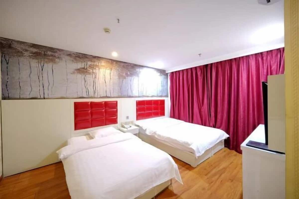 A hotel room with two beds, a red headboard, a large abstract painting on the wall, and a red curtain.