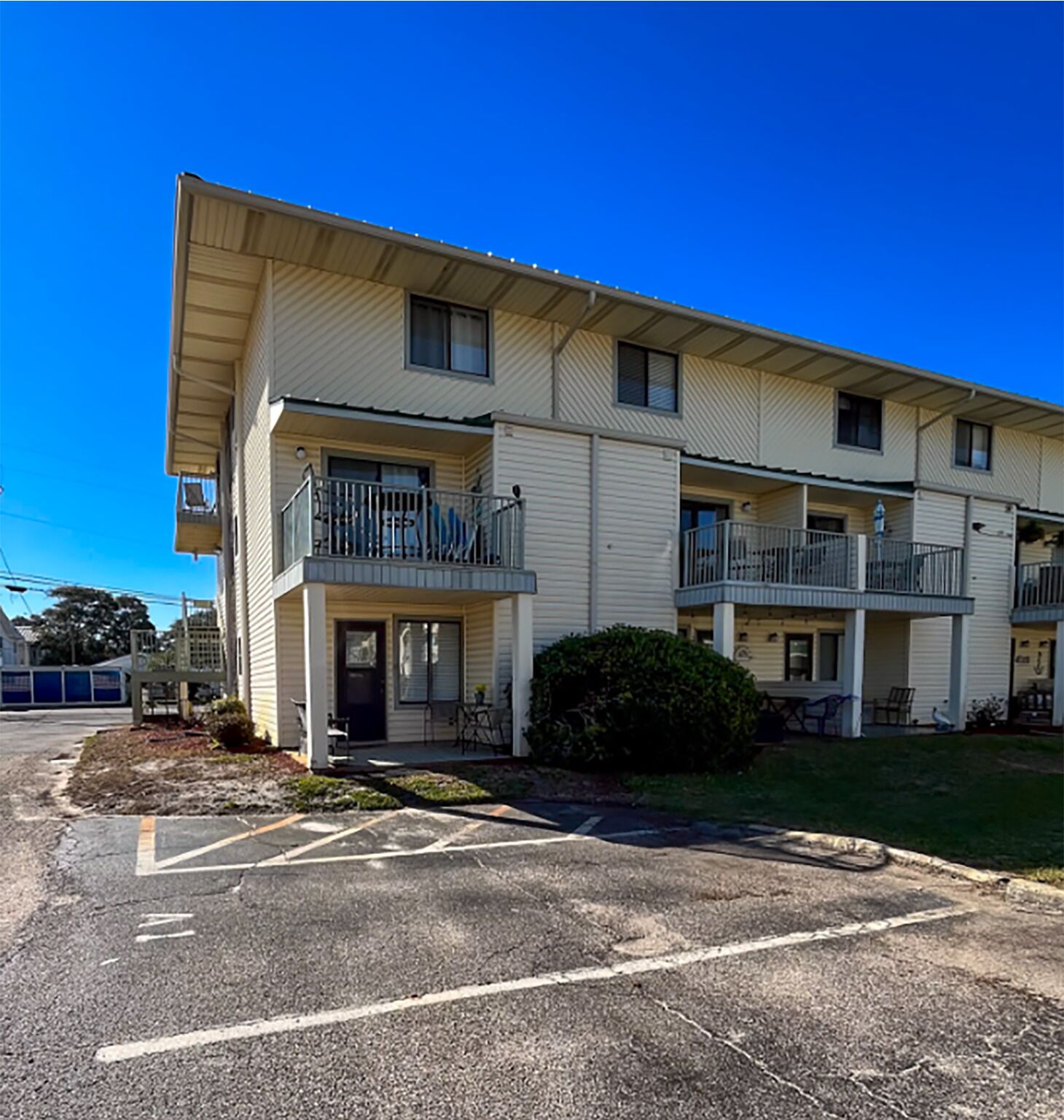 A multi-story motel with a parking lot in front.