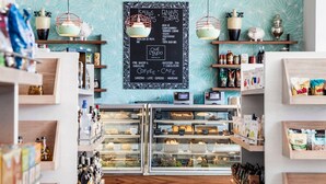 Une boulangerie dont le menu, écrit à la craie sur un tableau noir, propose des articles tels que « salades », « tortas de chez Pann » et « café et autres boissons ».