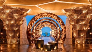 Un intérieur doté d’un élément architectural circulaire, d’un espace de détente central et d’une vue dégagée à travers la structure.