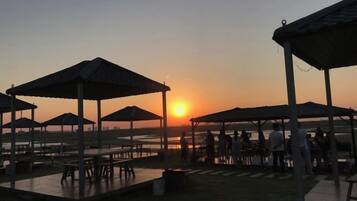 A sunset view with outdoor seating areas and a body of water.