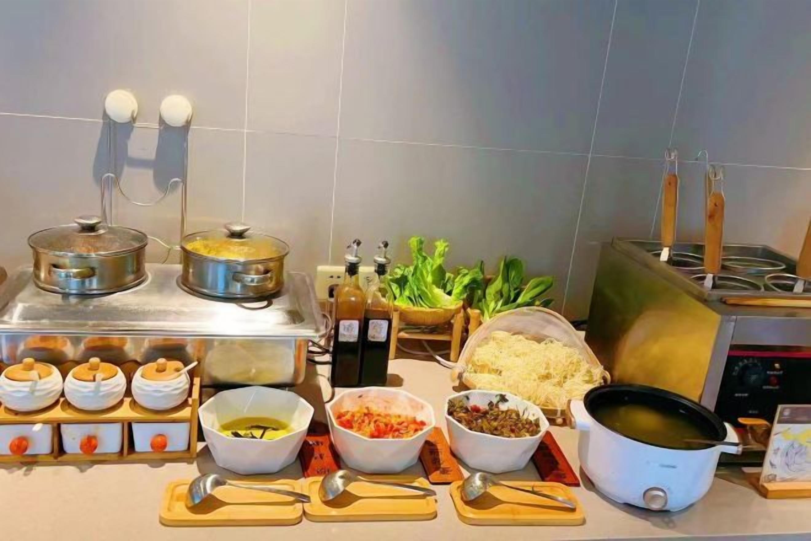 Una cocina con diferentes utensilios de cocina, ollas e ingredientes sobre la encimera.