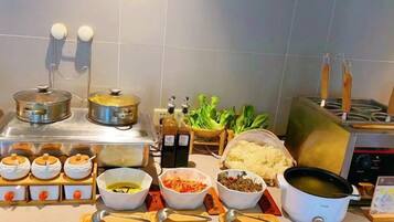 Una cocina con diferentes utensilios de cocina, ollas e ingredientes sobre la encimera.