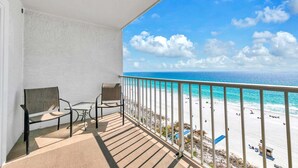 A balcony with a view of a beach and ocean.