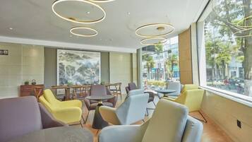 A modern interior with seating arrangements and a view through large windows.