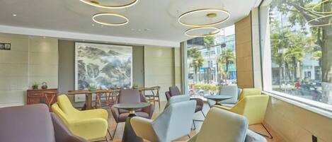 A modern interior with seating arrangements and a view through large windows.